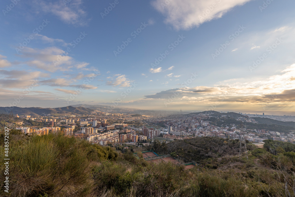 Panorama of Barcelona from the air in the early morning. City with shadows from the clouds. Dramatic sky over the city. Autumn in Barcelona, Spain.
