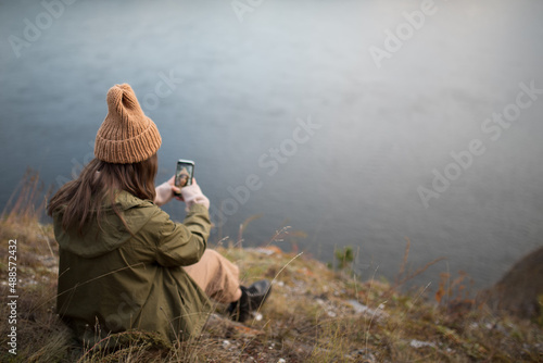 Portrait of a beautiful girl with smartphone in autumn outdoor.