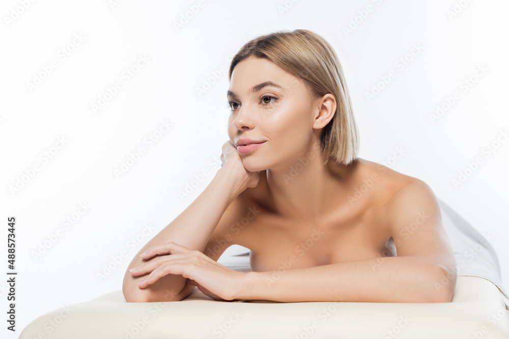 dreamy woman with bare shoulders lying on massage table on white dreamy woman with bare shoulders lying on massage table on white