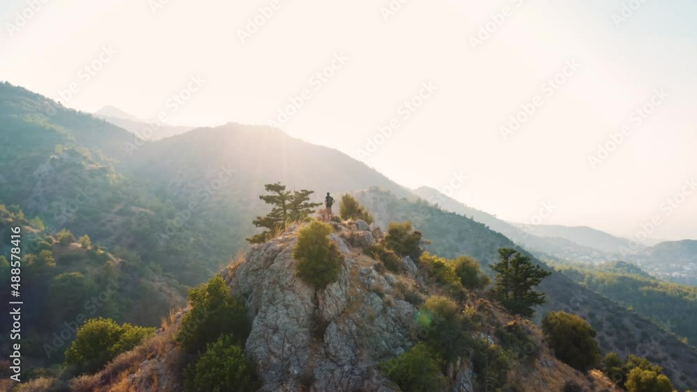 An aerial shot of a man on the peak of a mountain An aerial shot of a man on the peak of a mountain