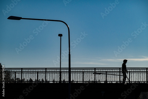 Photography Stockholm, Sweden A man in silhouette in the Flemingsberg suburb or district on a sunny winter day walks on a bridge