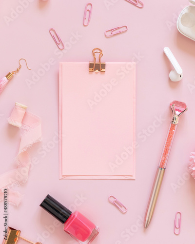 Paper with a clip and Pink school girly accessories on pastel pink Top view, mockup
