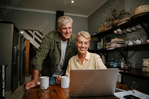 caucasian elderly couple smiling while talking to friends on video call