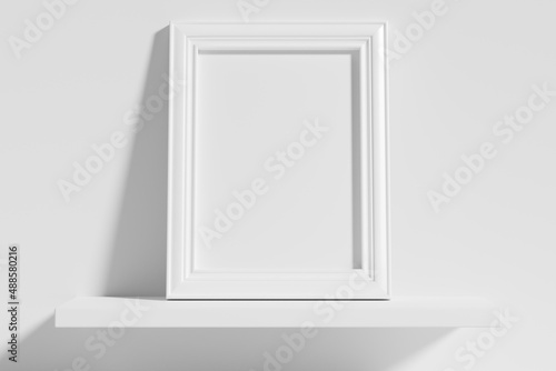 Rectangular photo frame on white shelf leaning at wall