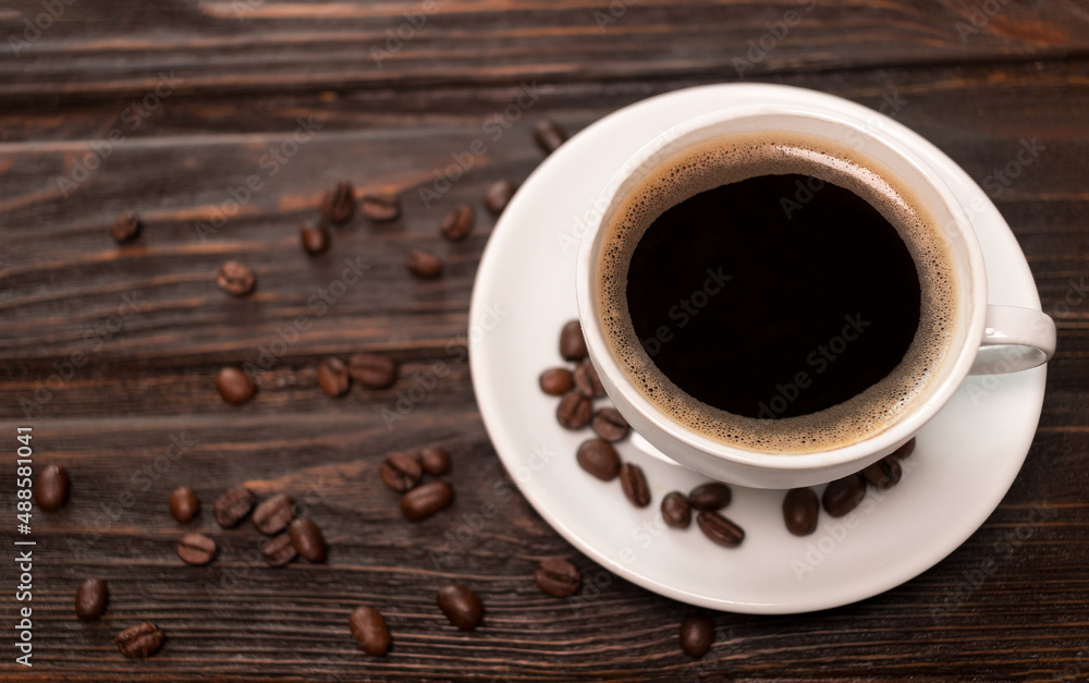 Coffee cup on old wooden table with cofee beans on plate, top view with copy space. Coffee cup on old wooden table with cofee beans on plate, top view with copy space.