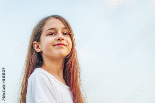 Portrait of a teenage girl with long hair against the sky. Girl 11 years old.