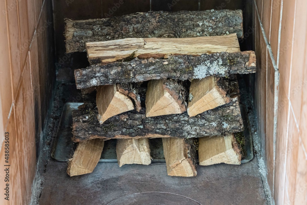 ussian wood stove. Close-up  Oak firewood stacked in oven dries. Dried oak firewood for burning in Russian stove