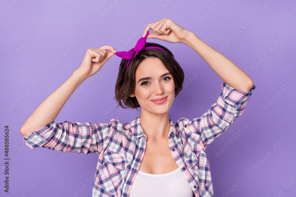 Photo of adorable charming lady fix adjust pink headband prepare evening date isolated on violet color background Photo of adorable charming lady fix adjust pink headband prepare evening date isolated on violet color background