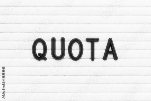 Black color letter in word quota on white felt board background photo