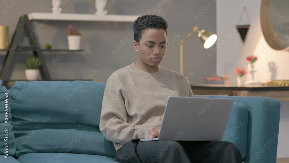 African Woman Working on Laptop on Sofa African Woman Working on Laptop on Sofa