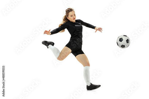 Leg kick. One sportive girl, female soccer player training with football ball isolated on white studio background. Sport, action, motion, fitness