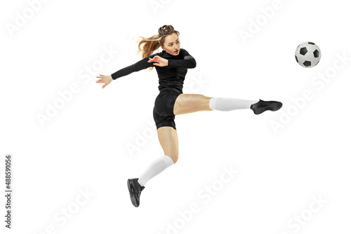 Attacking player. One sportive girl, female soccer player training with football ball isolated on white studio background. Sport, action, motion, fitness