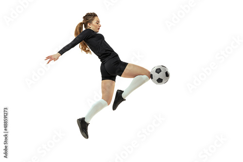 Attacking player. One sportive girl, female soccer player training with football ball isolated on white studio background. Sport, action, motion, fitness © master1305