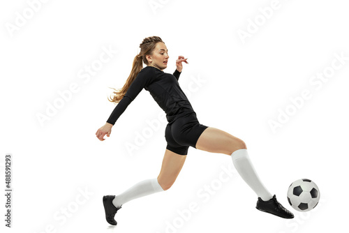 Workout. One sportive girl, female soccer player practicing with football ball isolated on white studio background. Sport, action, motion, fitness © master1305