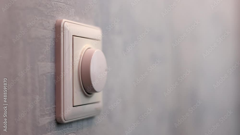 Male Hand Close-up Turns The Dimmer Switch On The Light Switch Male Hand Close-up Turns The Dimmer Switch On The Light Switch