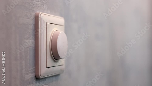 Male Hand Close-up Turns The Dimmer Switch On The Light Switch
