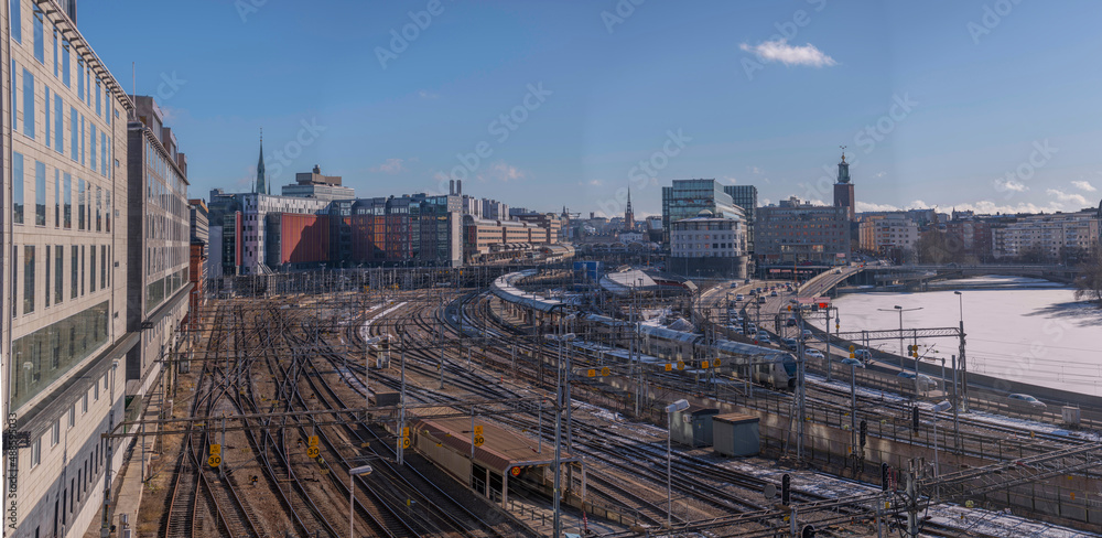 Panorama,  railway, central station, turn points, catenary, electric poles and tunnels. Train, office, station, hotel buildings. Icy canal Karlbergskanalen, in Stockholm