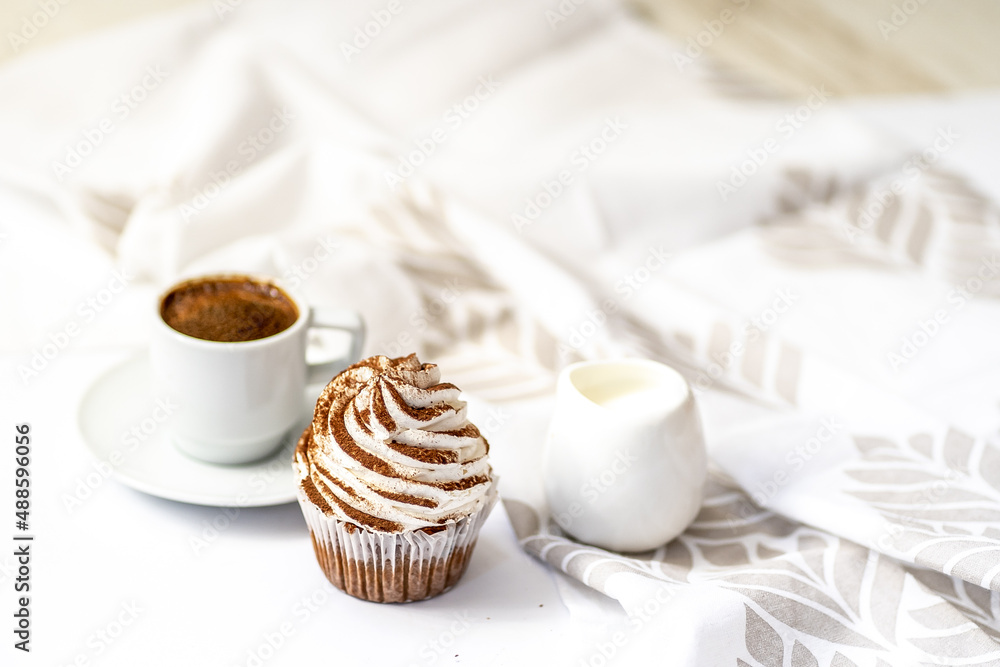 Black coffee with cupcakes and muffins. Spice cupcakes with creamcheese frosting decorated with a cocoa Black coffee with cupcakes and muffins. Spice cupcakes with creamcheese frosting decorated with a cocoa