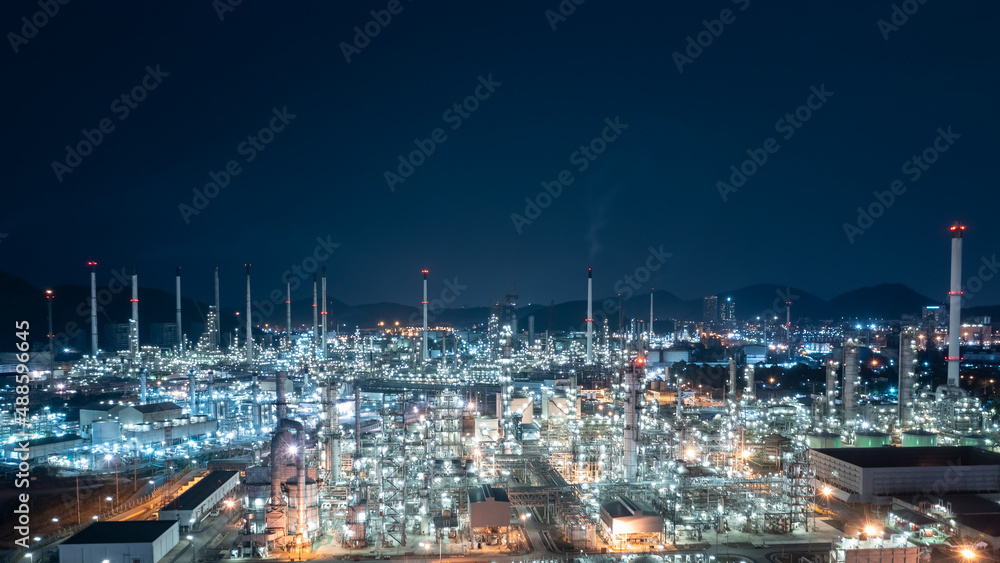 Oil and gas refinery plant or petrochemical industry at night sky, Manufacturing of petroleum industrial business aerial view photograph from drone
