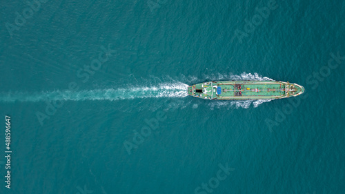 Aerial top view Oil ship tanker sailing full speed with beautiful wave and splash water in line of transportation from refinery in sea. photo