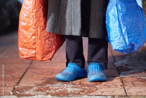 Фотография feet of refugees or homeless people in dirty cheap shoes