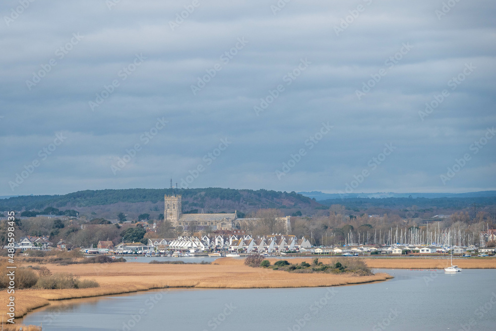 a view of Christchurch Priory Dorset England across the river