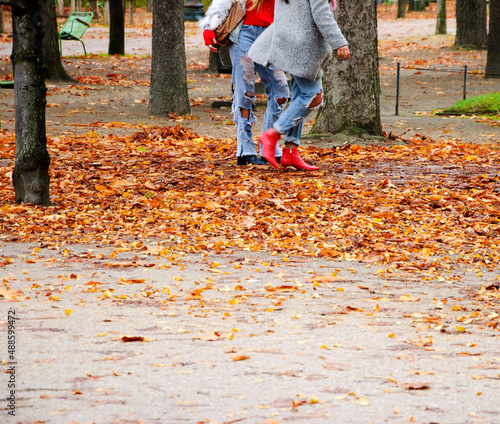 Paris. Autumn. Two trendy girls walking through a park in a hurry for shopping