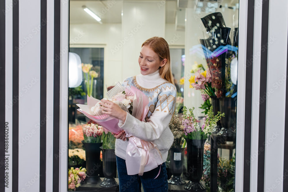 A young girl poses with a beautiful festive bouquet against the background of a cozy flower shop. Floristry and bouquet making in a flower shop. Small business. A young girl poses with a beautiful festive bouquet against the background of a cozy flower shop. Floristry and bouquet making in a flower shop. Small business.