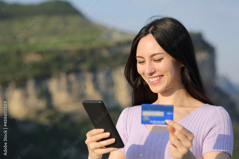 Asian woman buying online with credit card in nature Asian woman buying online with credit card in nature