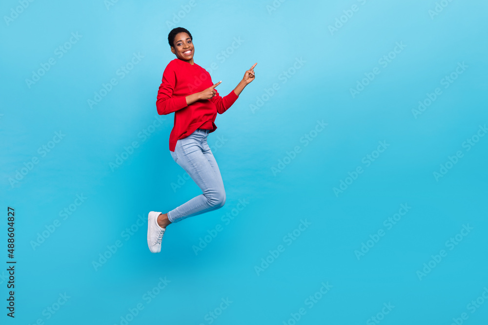 Full size photo of jumping beautiful appearance girl in stylish casual clothes promote sale discount isolated on blue color background