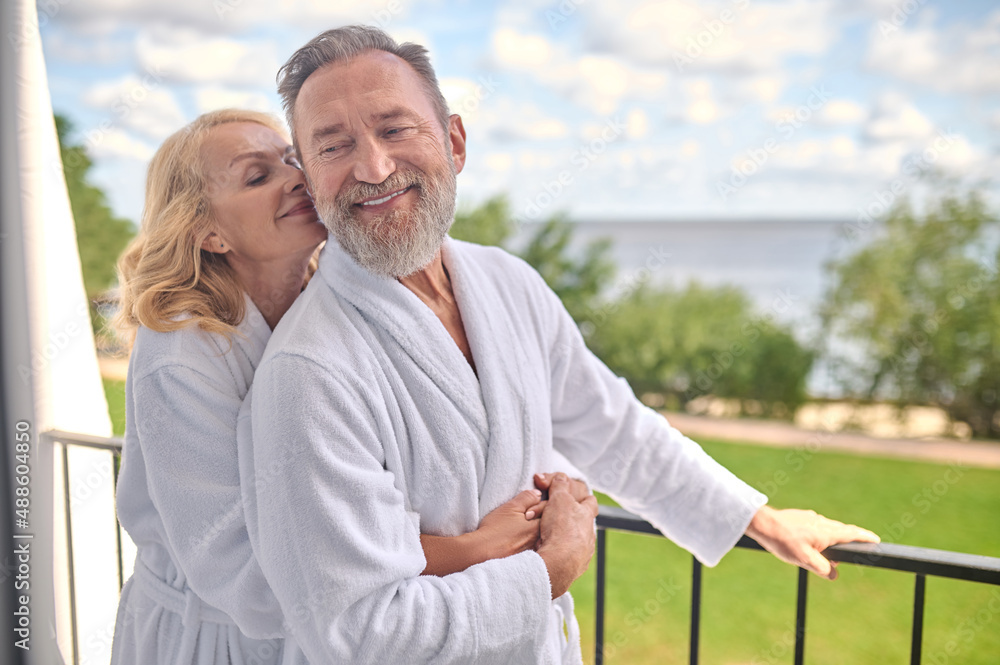 A couple at the balcony hugging and feeling amazing