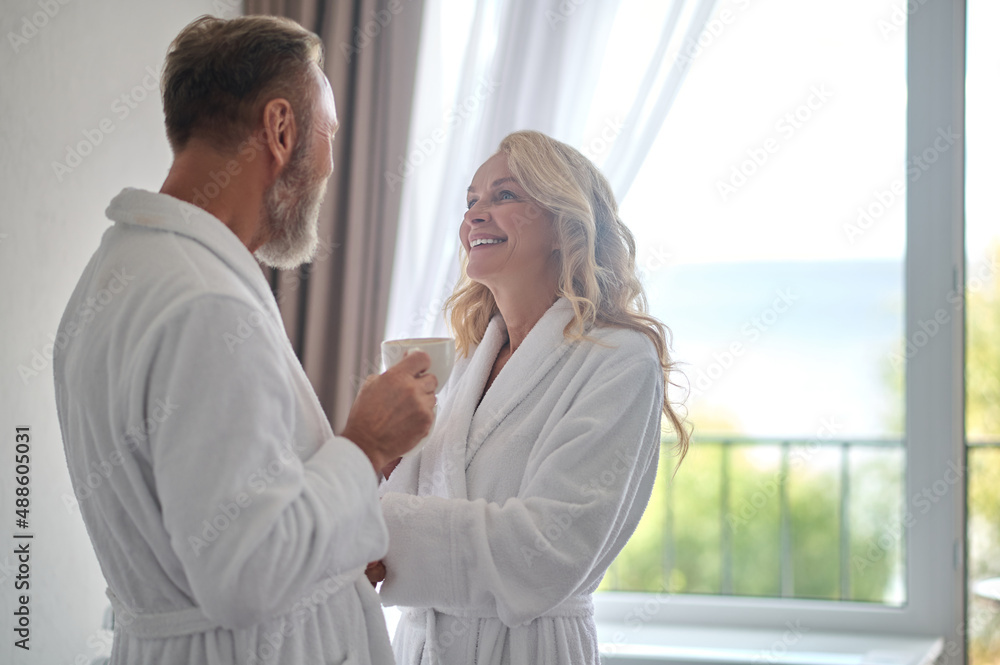 A happy mid aged couple in white robes feeling wonderful A happy mid aged couple in white robes feeling wonderful