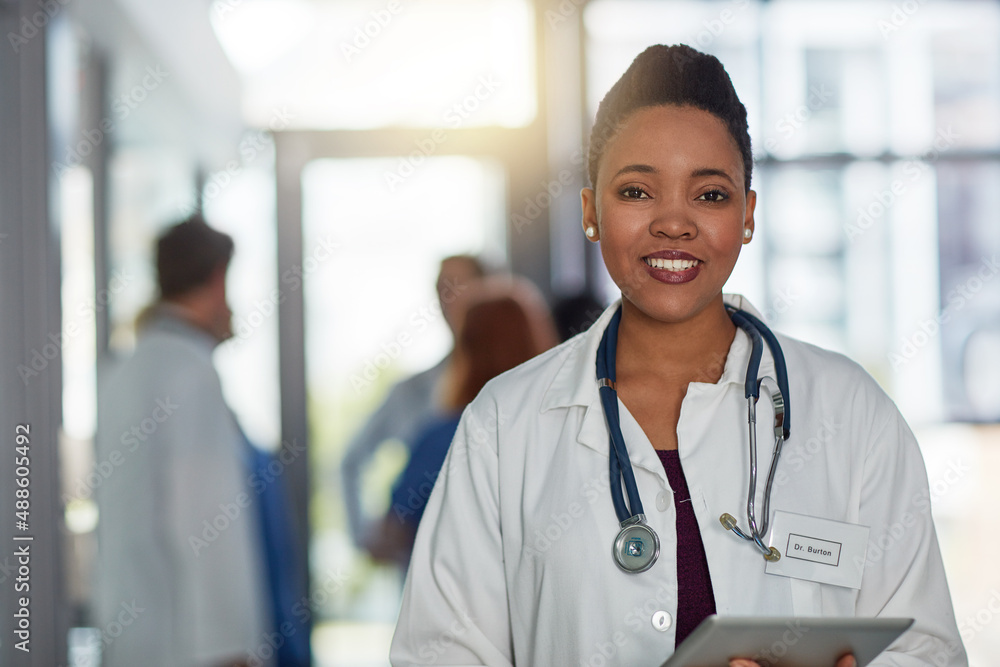 Quality healthcare is of utmost importance to me. Portrait of a young female doctor standing in a hospital with her colleagues in the background. Quality healthcare is of utmost importance to me. Portrait of a young female doctor standing in a hospital with her colleagues in the background.