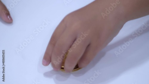 Slow motion scene of a 5-year-old Asian girl collecting bitcoins. fun at the table