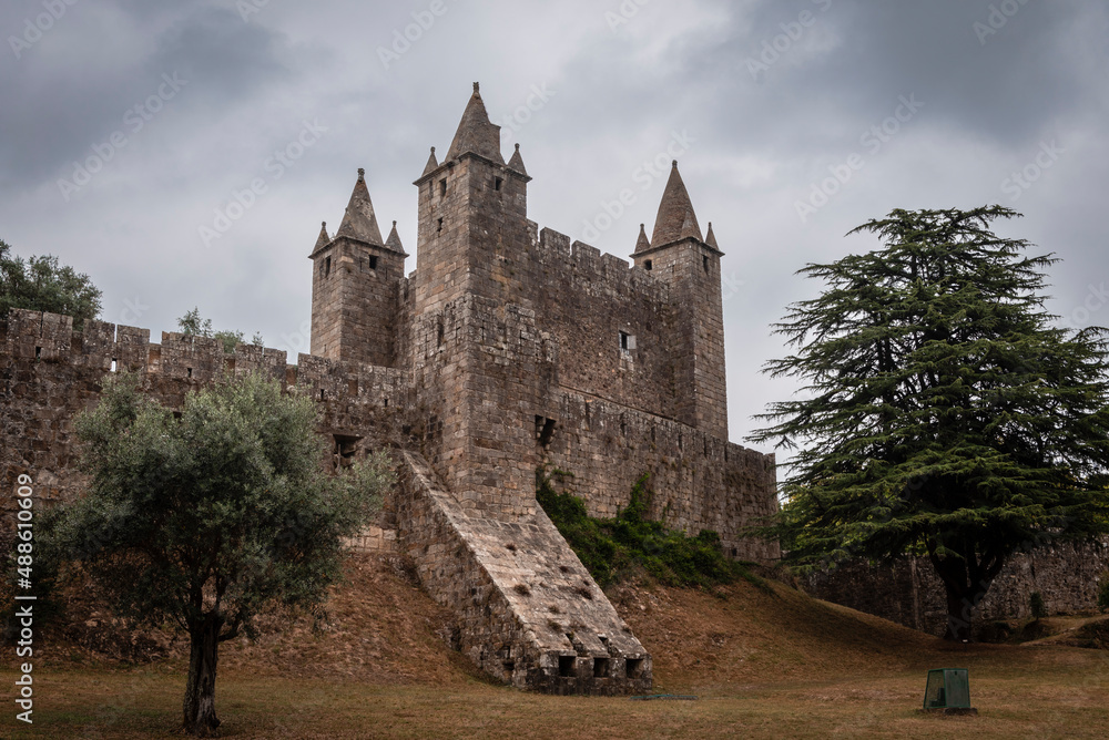 Impressive defensive castle of Santa Maria da Feira, on a hill and under a cloudy sky
