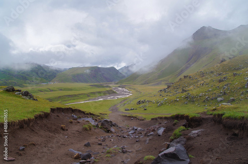 Road to Glade of Emmanuel. Scenic view of of Kyzylkol river valley in cloudy day. Nature and travel. Russia, Caucasus, Kabardino-Balkaria, near Mount Elbrus photo