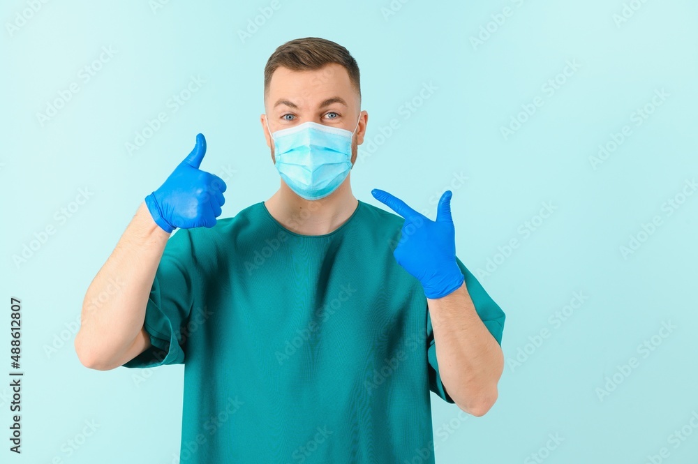 Vaccination against coronavirus. Testing COVID-19 vaccines. A male doctor in a medical mask fills a syringe the with a COVID-19 vaccine on a blue background. Doctor's hands hold a syringe close-up. Vaccination against coronavirus. Testing COVID-19 vaccines. A male doctor in a medical mask fills a syringe the with a COVID-19 vaccine on a blue background. Doctor's hands hold a syringe close-up.