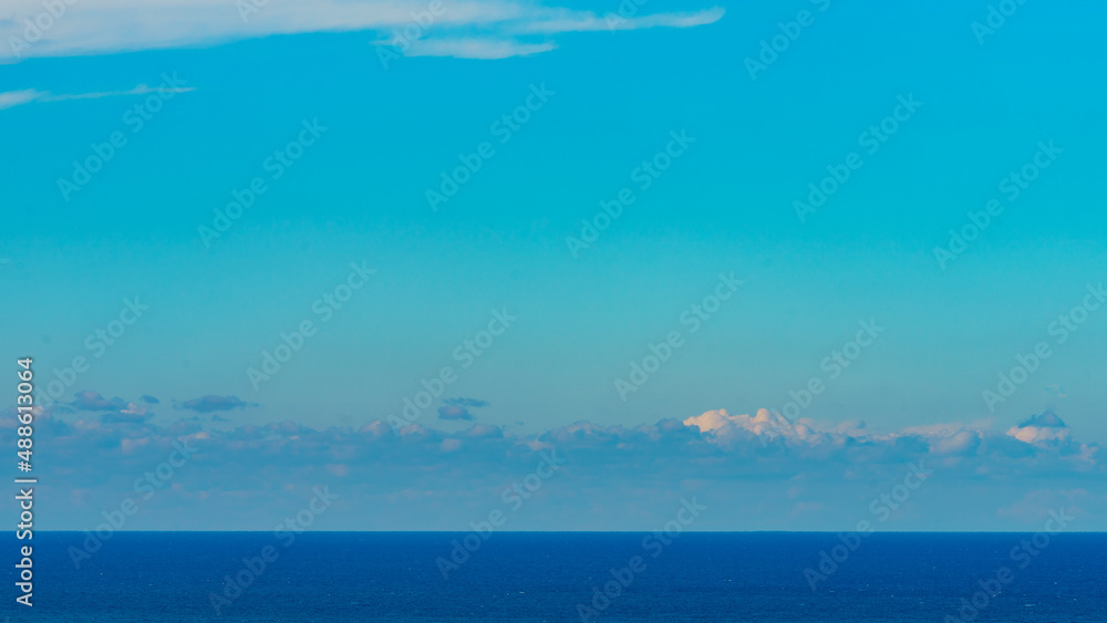 Panoramic view of bright blue sea, blue sky with fluffy white clouds