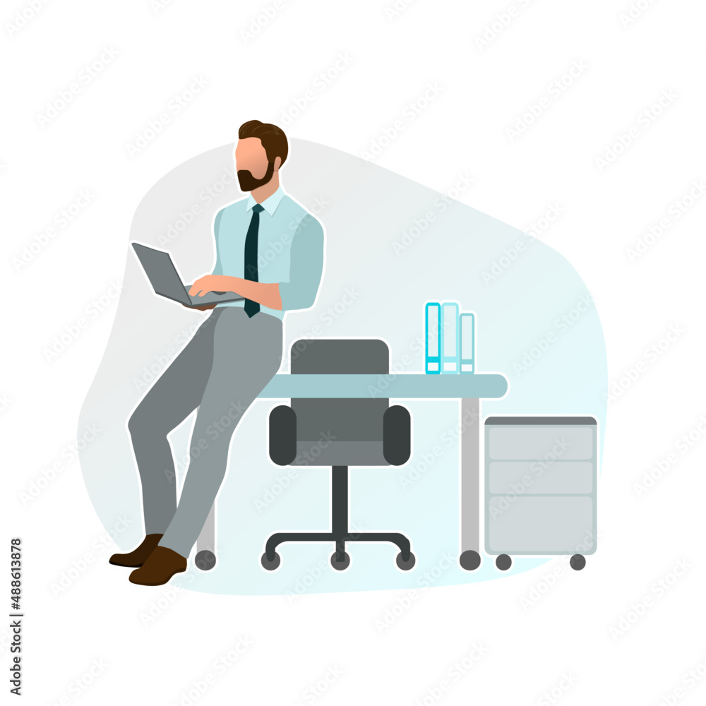 Male manager leaning on the desk in the office with a laptop in his hands