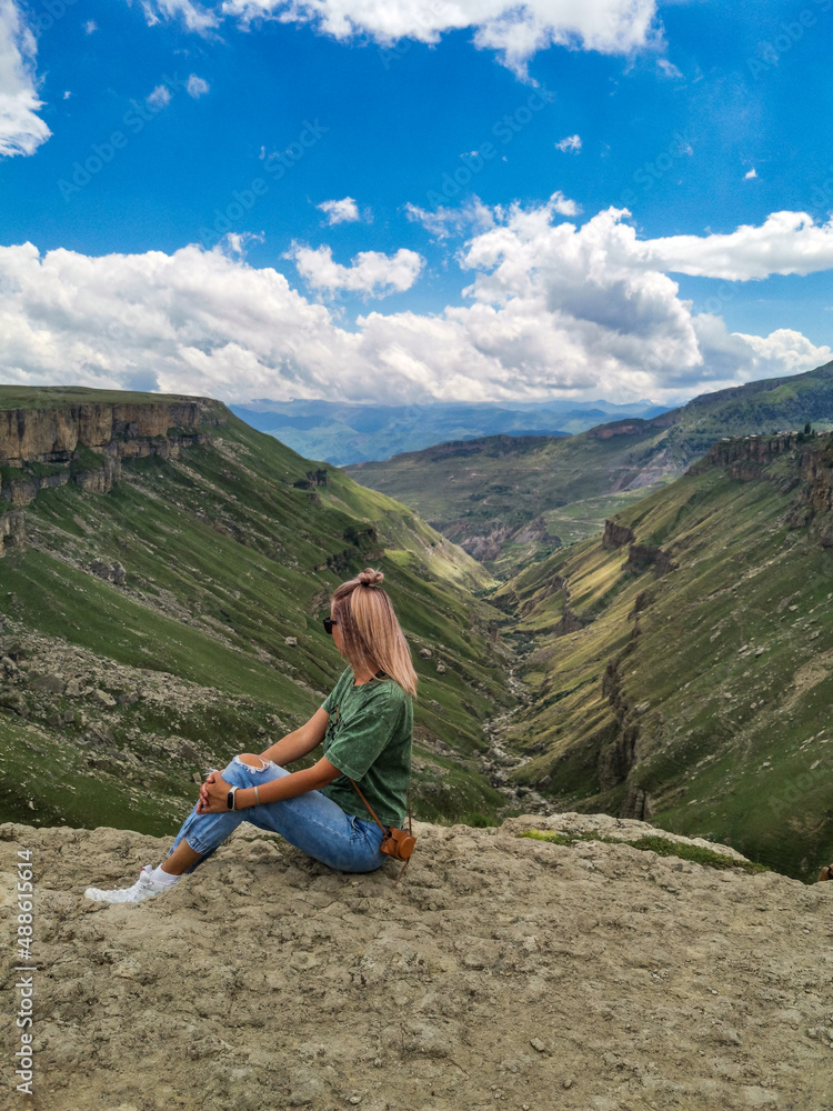 Fototapeta premium A girl on the background of the Khunzakh valley, Khunzakh waterfalls, Dagestan 2021