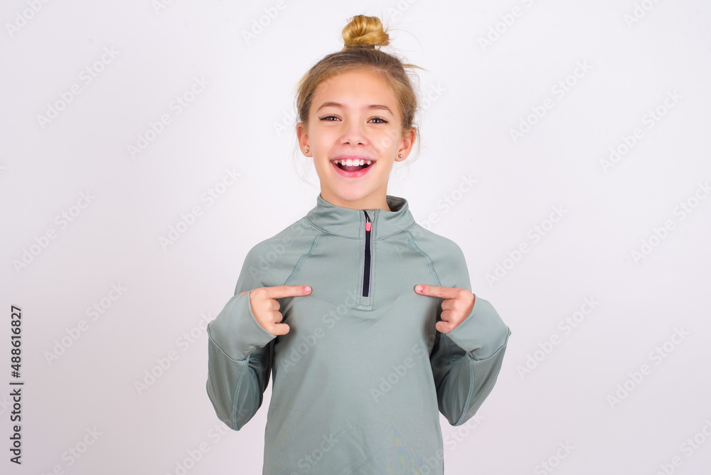 little caucasian kid girl with hair bun wearing technical shirt over ...