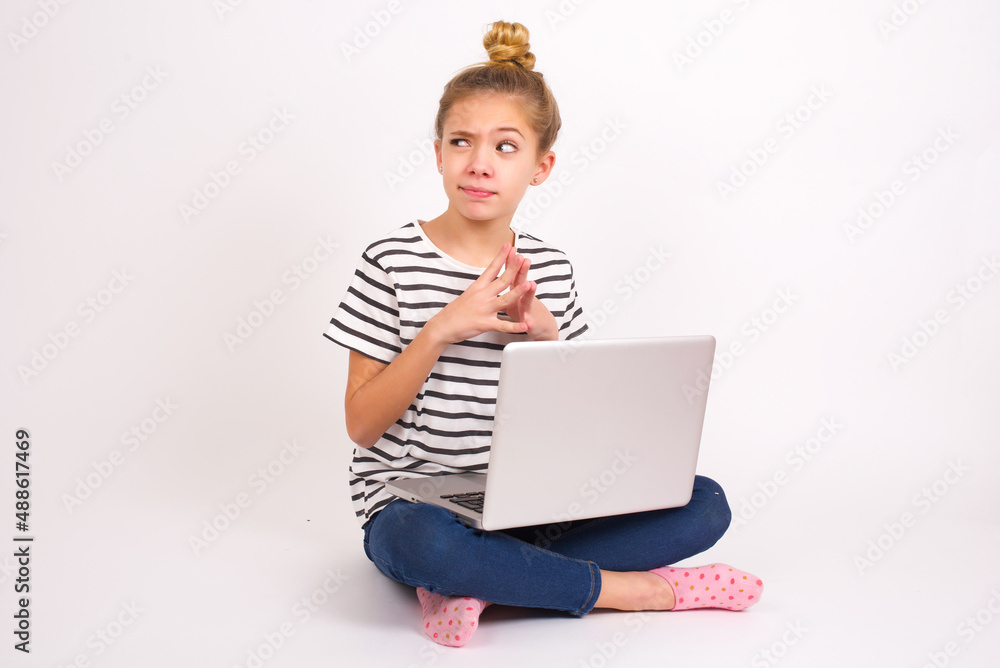 caucasian teen girl sitting with laptop in lotus position on white background steepls fingers and looks mysterious aside has great evil plan in mind caucasian teen girl sitting with laptop in lotus position on white background steepls fingers and looks mysterious aside has great evil plan in mind