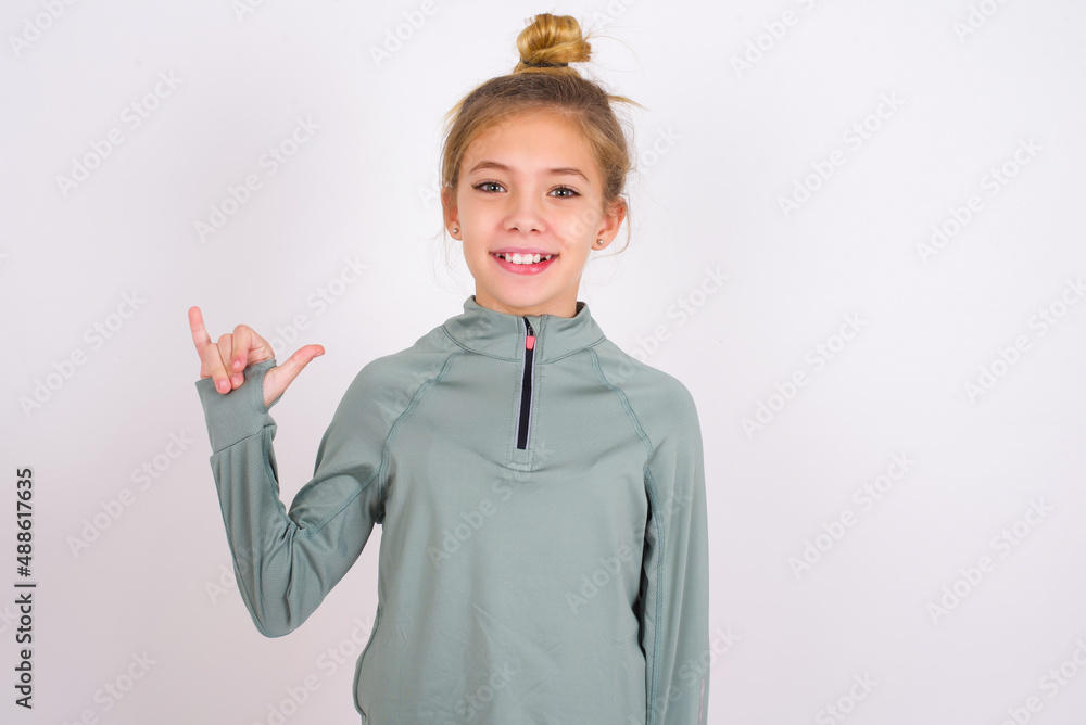 little caucasian kid girl with hair bun wearing technical shirt over ...