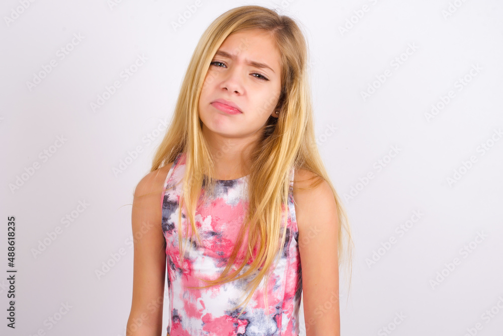 little caucasian kid girl wearing sport clothing over white background depressed and worry for distress, crying angry and afraid. Sad expression.