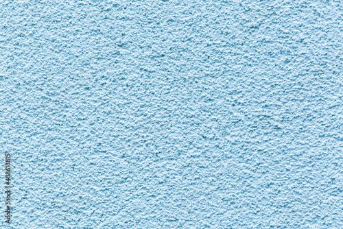 Sample of a texture of blue plaster. Wall finished with a decorative cement stucco. Example of exterior building decoration. Clean uniform grainy background. Banner. Wallpaper. Copy space. Pattern