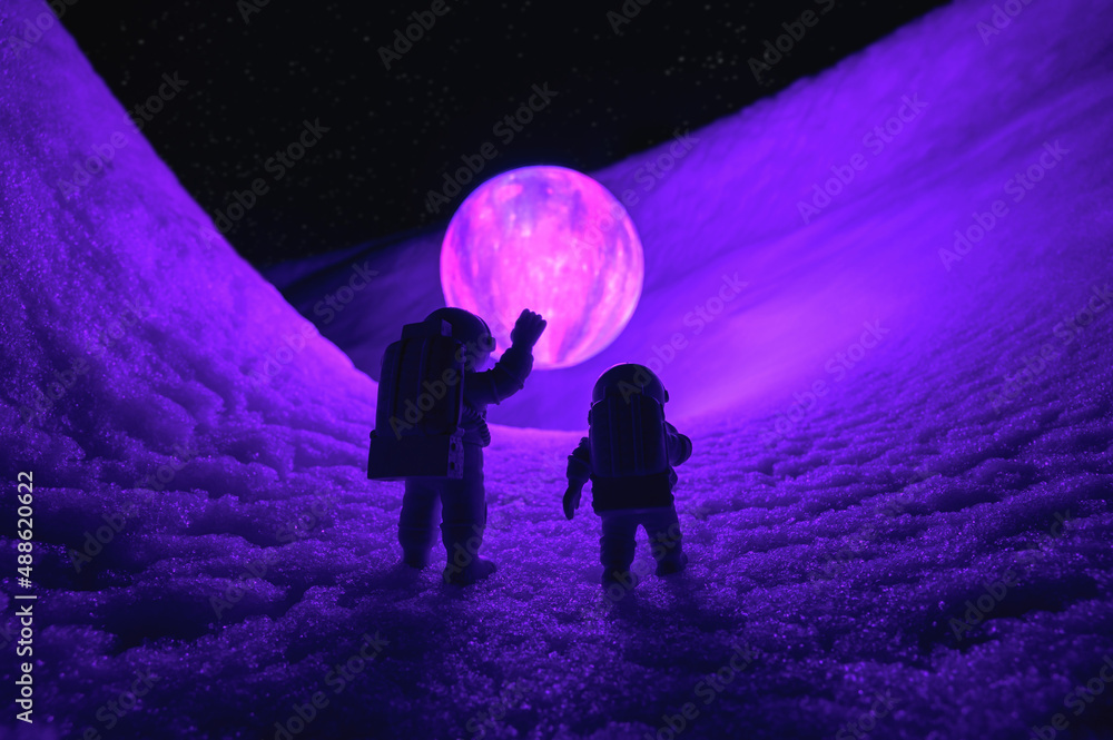 Silhouettes of the toys of astronauts against levitating glowing sphere over surface icy planet covered with snow. Concept of space travel, exploration, and colonization