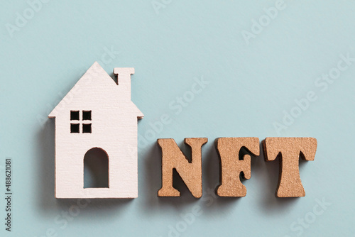 Non-fungible token. NFT, White wooden house on blue background. Tokenizing Real Estate Property. Blockchain Decentralized Real Estate Market. Rent or buy house for ETH. photo