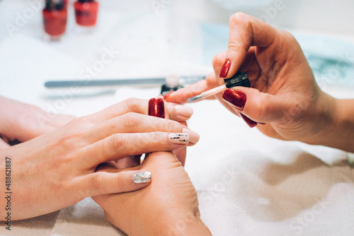 Painting your nails with red nail polish