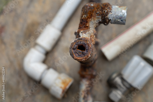 Rusted and oxidized galvanized water pipe, closeup of waste in old water pipes Clogged debris and corroded rust in old plumbing pipes. Selective focus