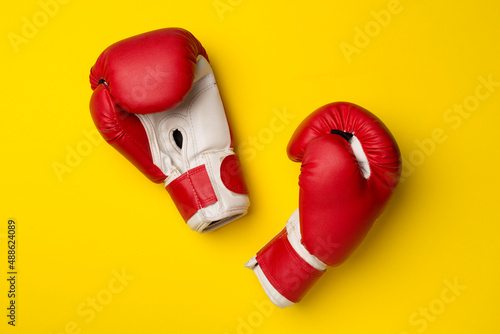 Pair of red boxing gloves on color background. Top view © Liami
